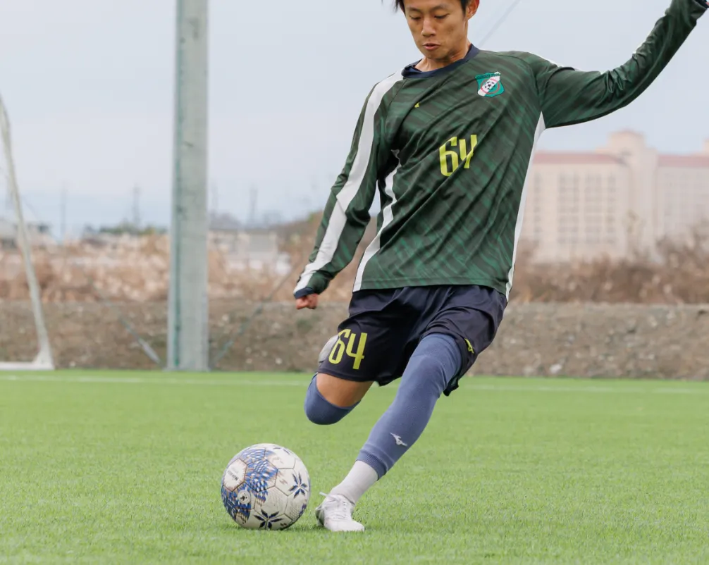 部活動でのサッカーのワンシーンで選手がボールをける瞬間の写真