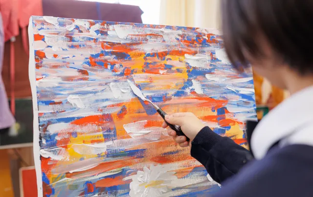 パレットナイフを使い、抽象画を制作している美術部の部員の手元