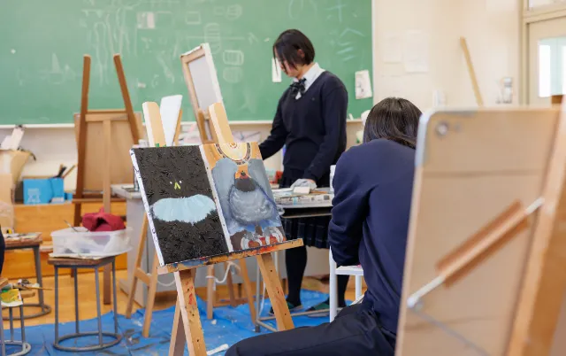 複数のイーゼルと作品が並ぶ、美術部の制作風景