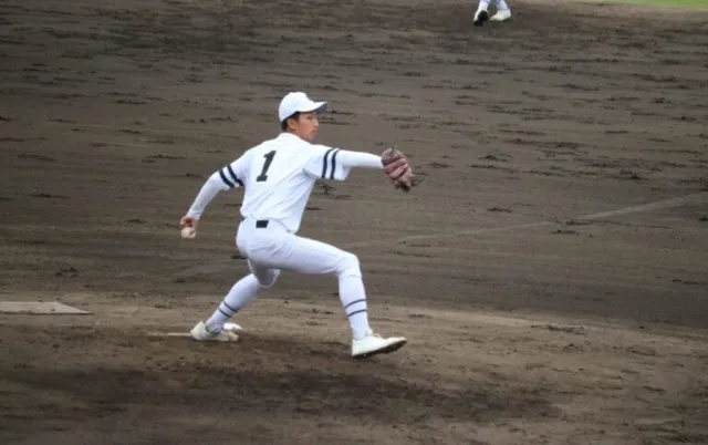 野球場で、投手がマウンドから投球動作をしている様子