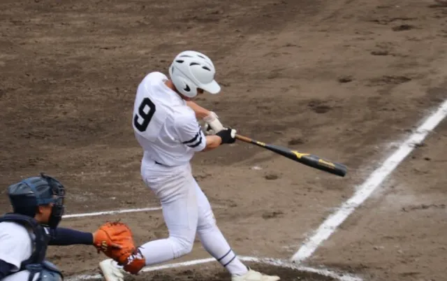 野球場で、打者がバットを振りスイングしている様子