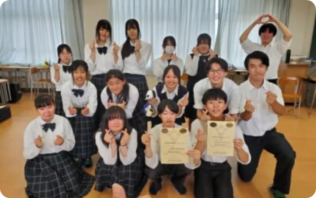 コンクールで表彰状を手にし、部員が集合して記念撮影している様子