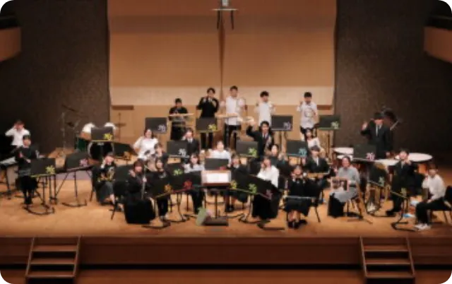 コンサートホールのステージで演奏を行う吹奏楽部の全体風景