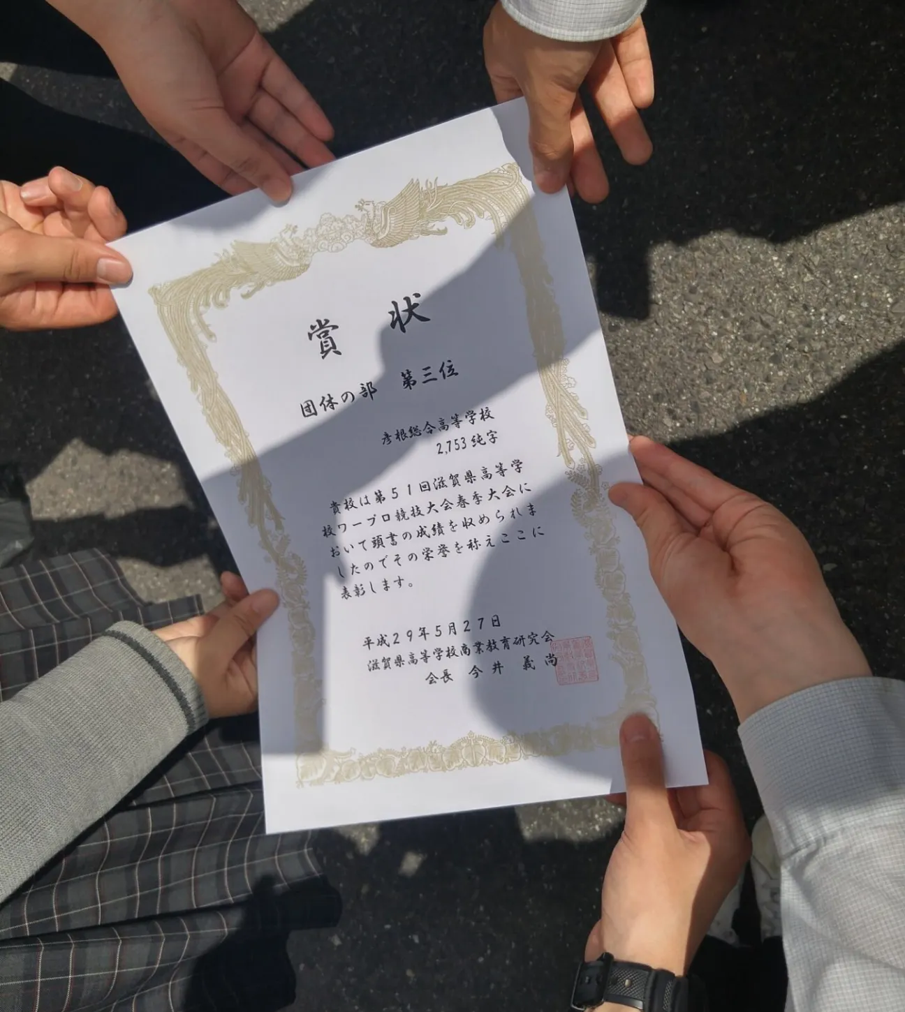 コンピュータ部が大会で受賞し、賞状を手にしている様子