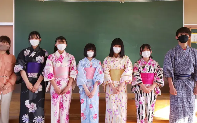 色とりどりの浴衣を着た部員が横一列に並んで立っている様子