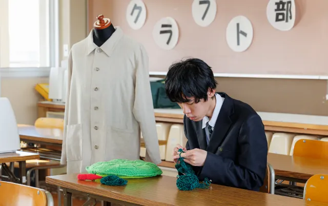 机に向かい、毛糸を使ったクラフト制作に集中している部員の様子