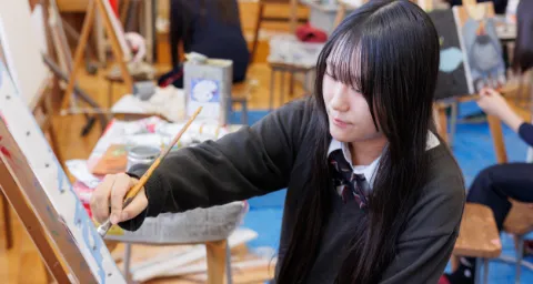美術部で、キャンバスに向かい絵を描いている部員の活動の様子