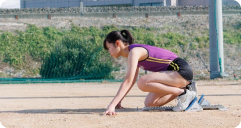 陸上競技部で、トラックのスタート位置に構える部員の様子