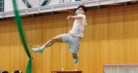 ハンドボール部で、ジャンプしてボールを投げるプレーの様子