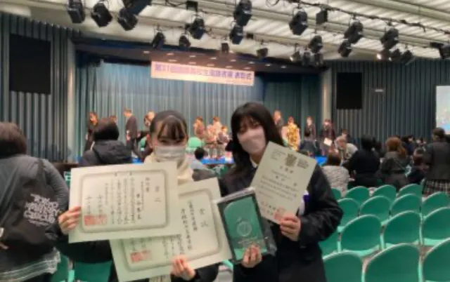 書道の表彰で、部員が賞状を手にしている様子