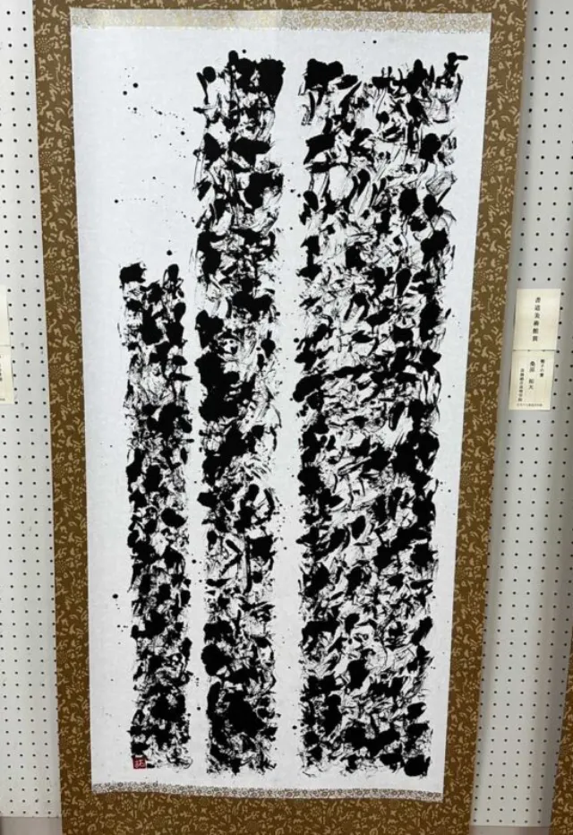 作品展で、掛け軸作品が展示されている様子