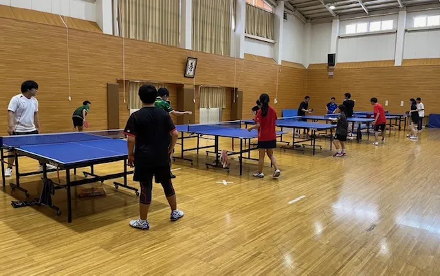 複数の卓球台が並び、部員が練習している様子
