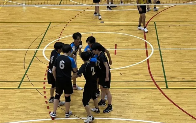 バレーボール部の部員が円陣を組んで集まっている様子