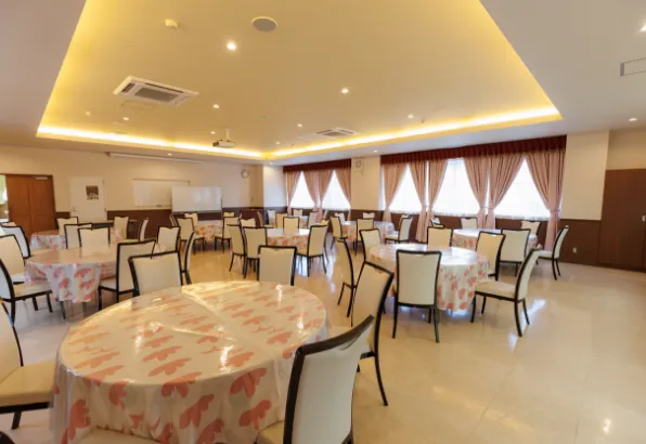 バンケットホール「ホールさくら」の内観。丸テーブルと椅子が多数配置された、広い室内スペース