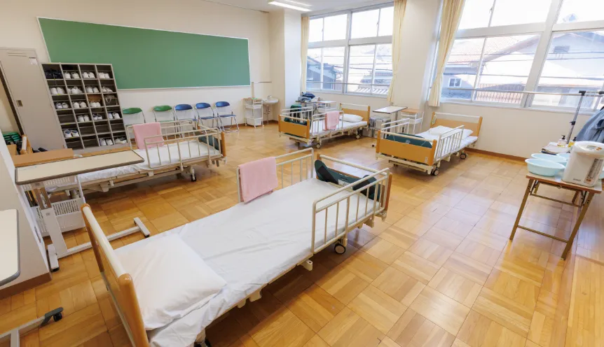 福祉の実技や演習などの実習授業で使用される、介護ベッドが並んだ実習室