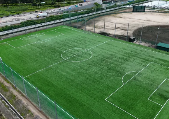 白線が引かれた芝の松隆グラウンドを上から見た様子